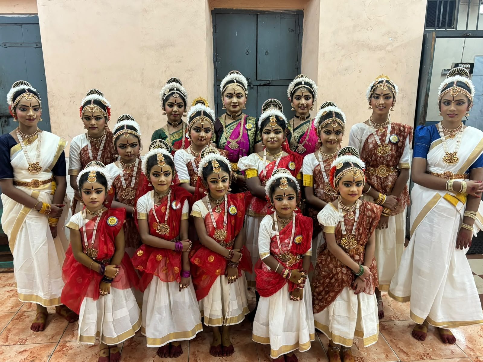Natya Deepika students in traditional white and maroon dance attire with temple jewelry